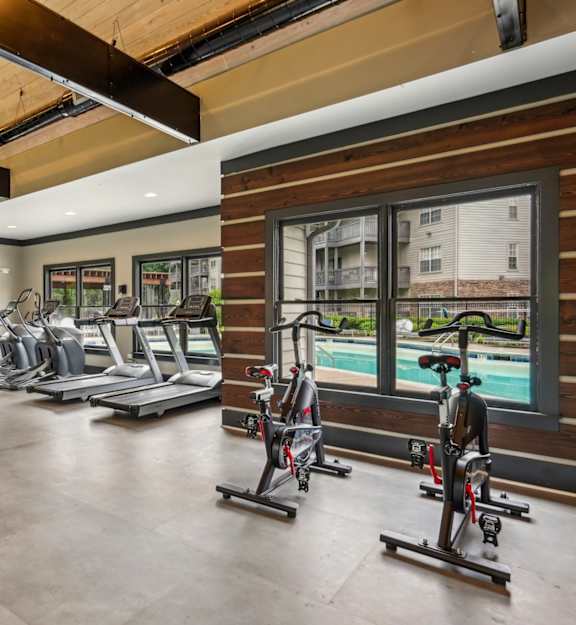 a gym with treadmills and other exercise equipment and a pool