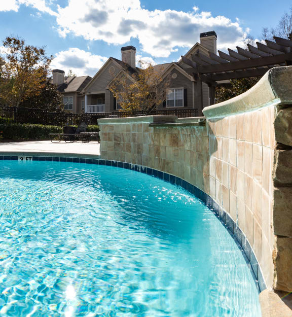 a swimming pool with a house in the background