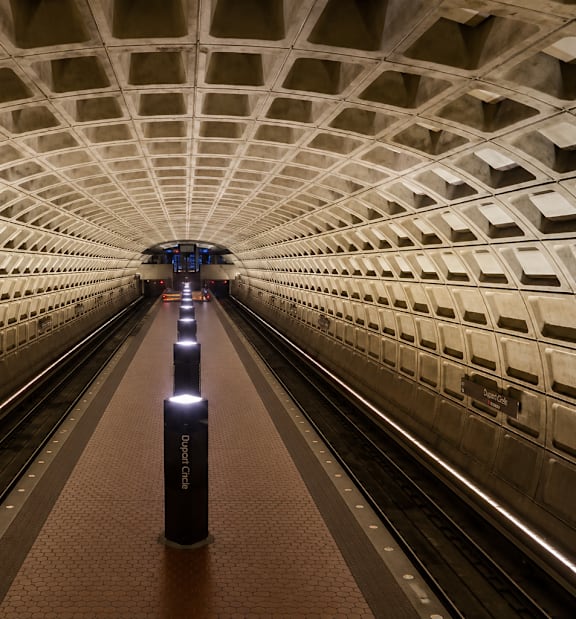 A subway train is approaching a platform in a tunnel.