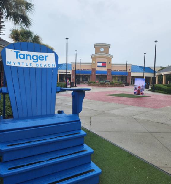 A blue chair with the words Tanger Myrtle Beach on it.