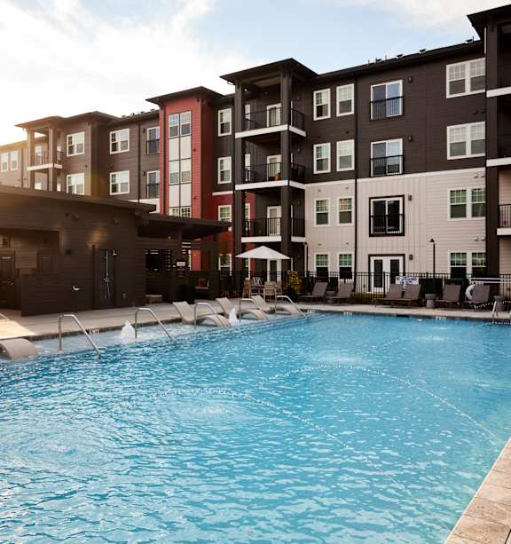 A swimming pool in front of apartment buildings.