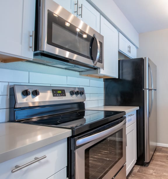 a kitchen with white cabinets and stainless steel appliances