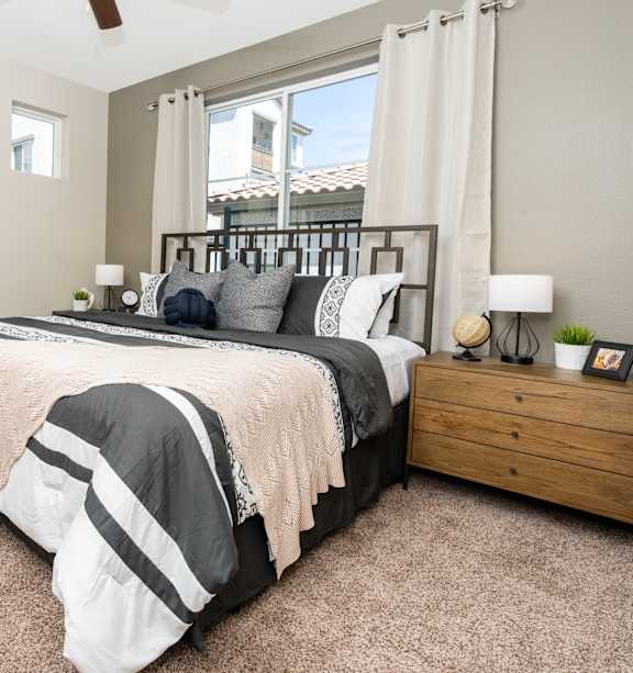 A bedroom with a large bed and a window overlooking a building.