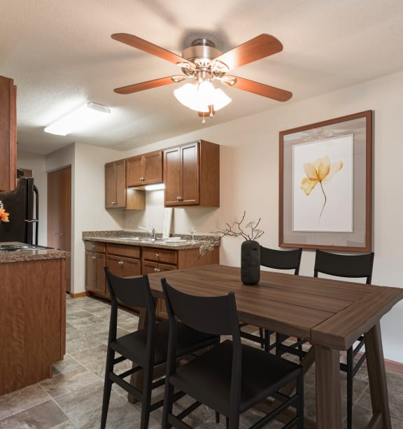 Bismarck, ND Parkview Arms |An open kitchen and dining room with a table and chairs and a ceiling fan Bismarck, ND Parkview Arms |An open kitchen and dining room with a table and chairs and a ceiling fan