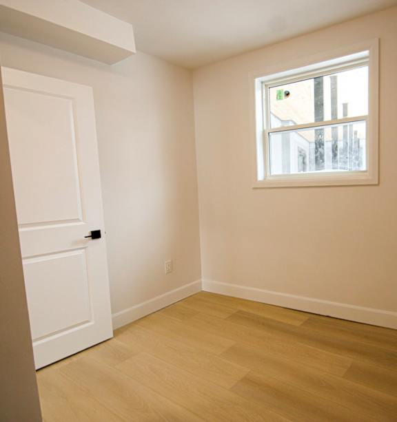 A room with a white door and a black object on the floor.