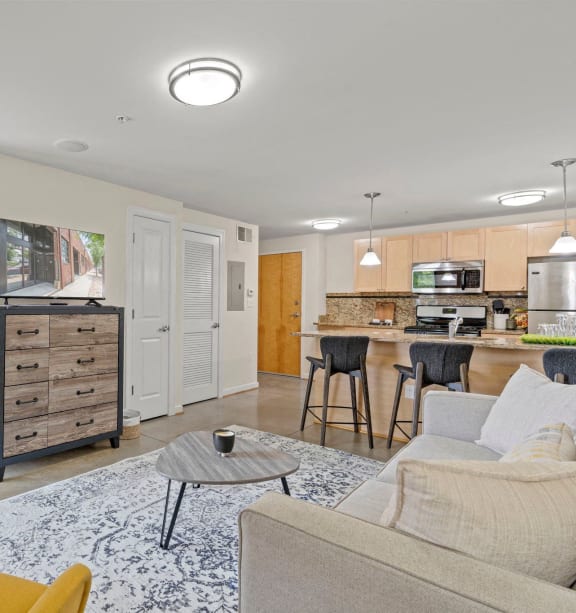 a living room and kitchen with a couch and a table