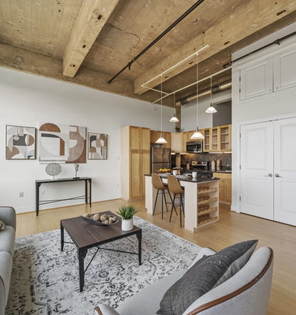 a living room with a couch and a table in front of a kitchen
