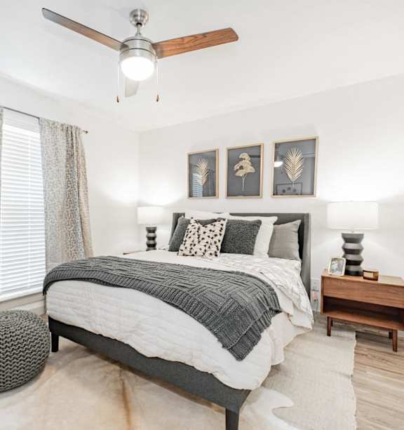 A bedroom with a bed, a ceiling fan, and a rug.