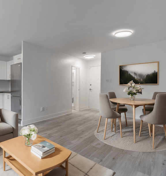 the living room and kitchen of an apartment with wood floors and white cabinets at 177 Saint George in Toronto, CA
