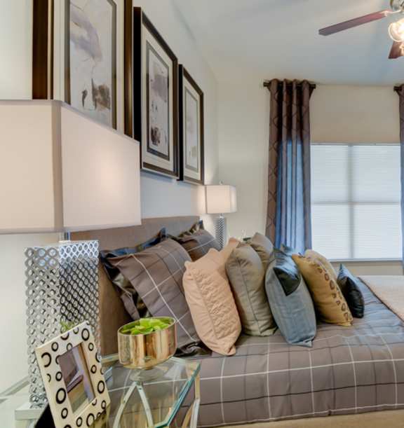 A bedroom with a bed, dresser, and mirror.