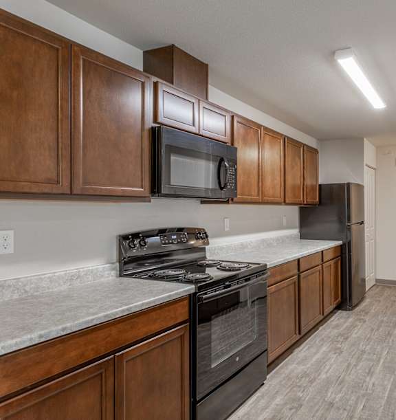 A kitchen with dark wood cabinets and stainless steel appliances.