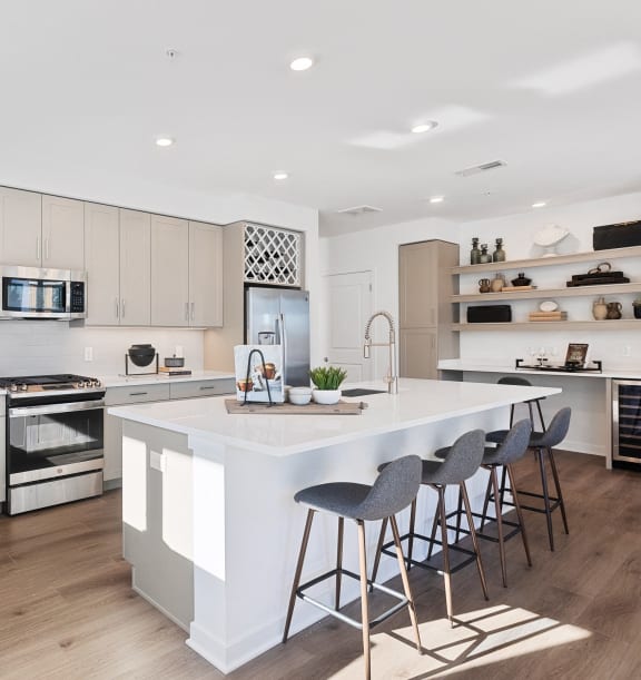 a large white kitchen with a large island and bar stools at Stonehill at West Orange, West Orange, New Jersey