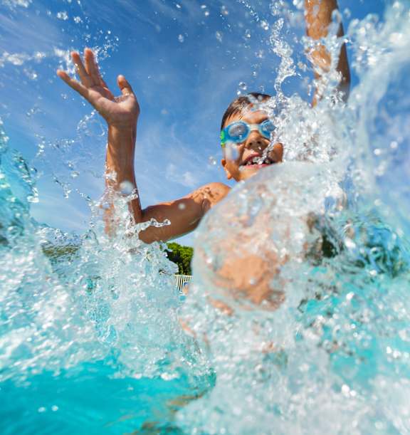 A person swimming in a pool with water splashing around.