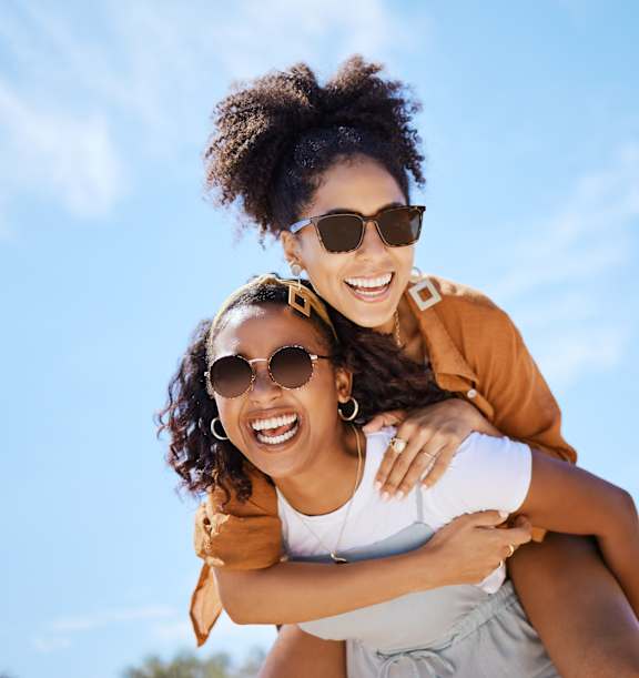 Two people are enjoying a piggyback ride outdoors.