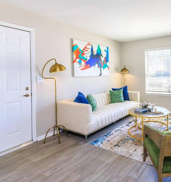 a living room with a couch and a table and a lamp