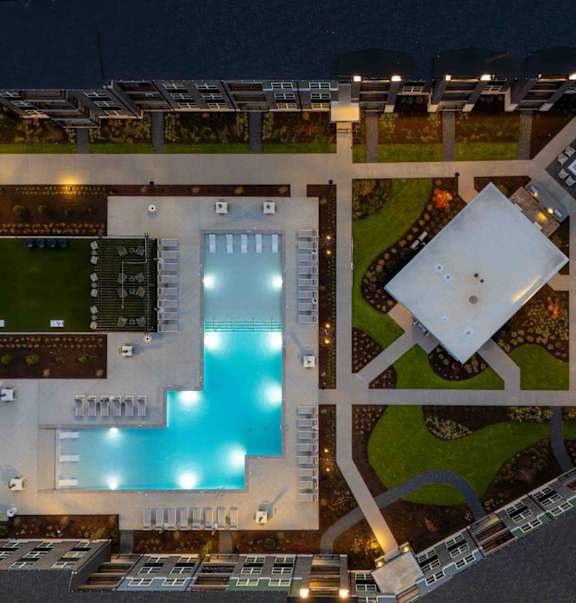 A modern building with a swimming pool at night.