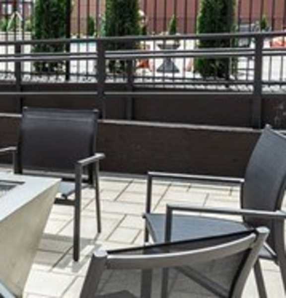 A patio with a table and chairs2 and a fountain.
