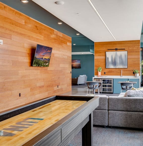 a living room with a wooden wall and a shuffleboard