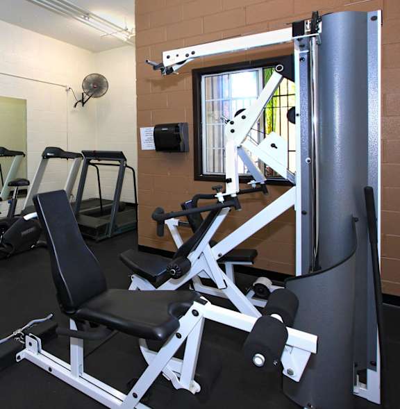 A gym with a variety of equipment including treadmills, weights, and exercise machines.
