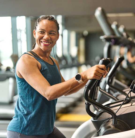 A woman is working out on a treadmill in a gym.