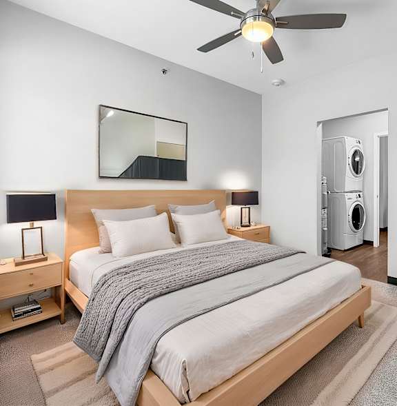 A bedroom with a bed, nightstand, and a ceiling fan.