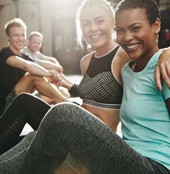 A group of people are sitting in a circle and smiling.