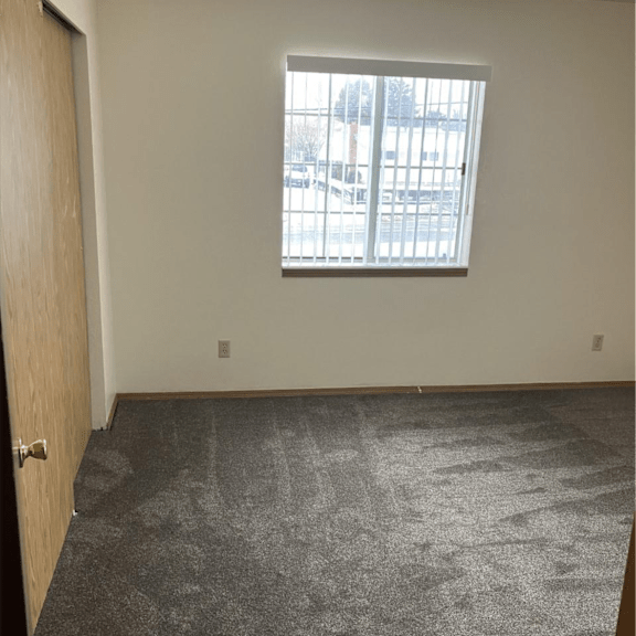 the living room of an empty house with a window