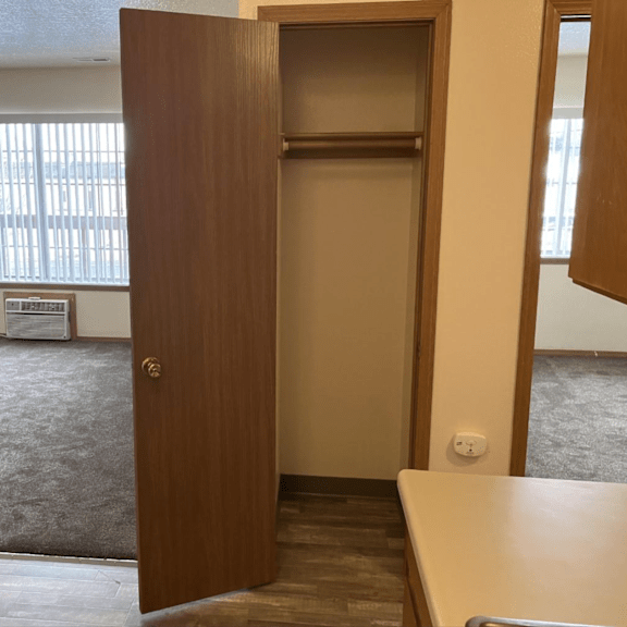 an empty kitchen and living room with an open door