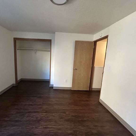 a room with a brown floor and white walls.