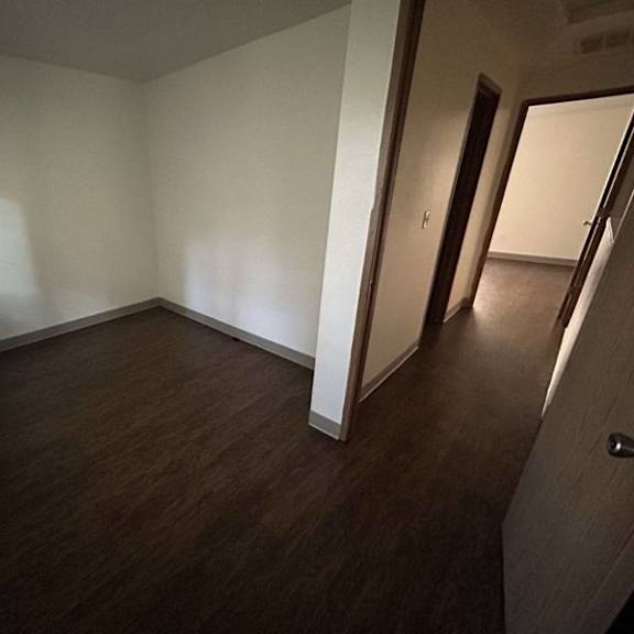 a room with wooden floors and white walls.