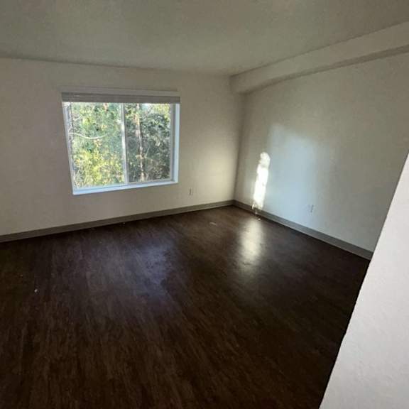 a room with wooden flooring and a window.