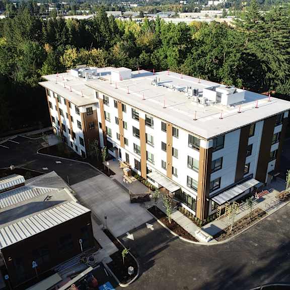 an aerial view of a four story building with a white roof