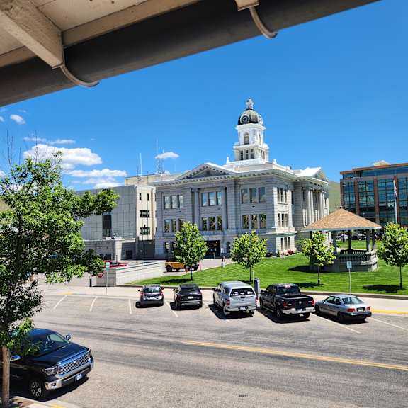 a view of a street with cars and a building with a dome on top.