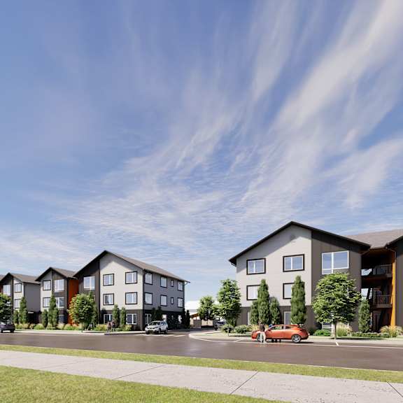 a row of modern townhouses with cars parked in front.