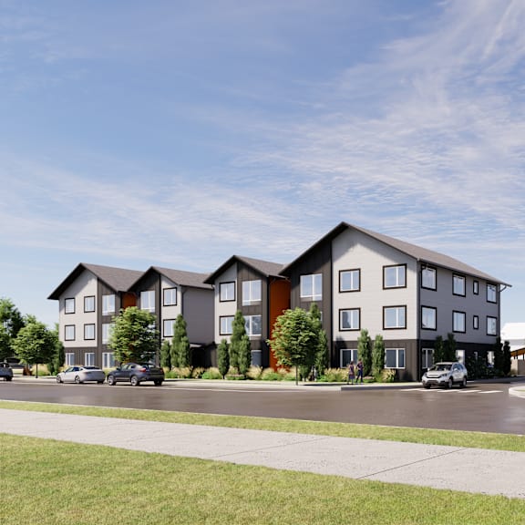 a row of modern townhouses with cars parked in front.