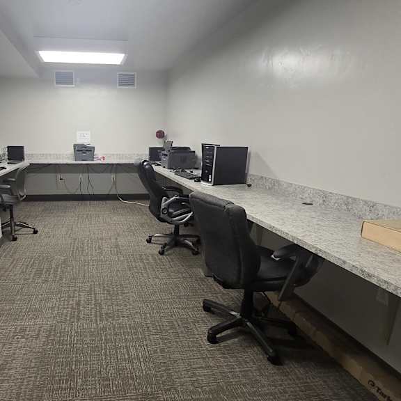 a room with a row of desks and chairs.