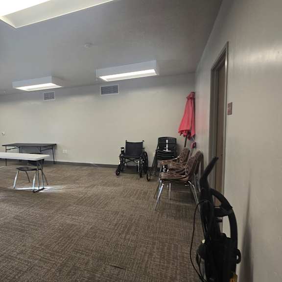 a room with tables and chairs and a wheelchair.