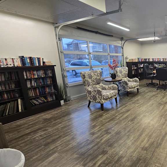 a library with a lot of books and chairs.