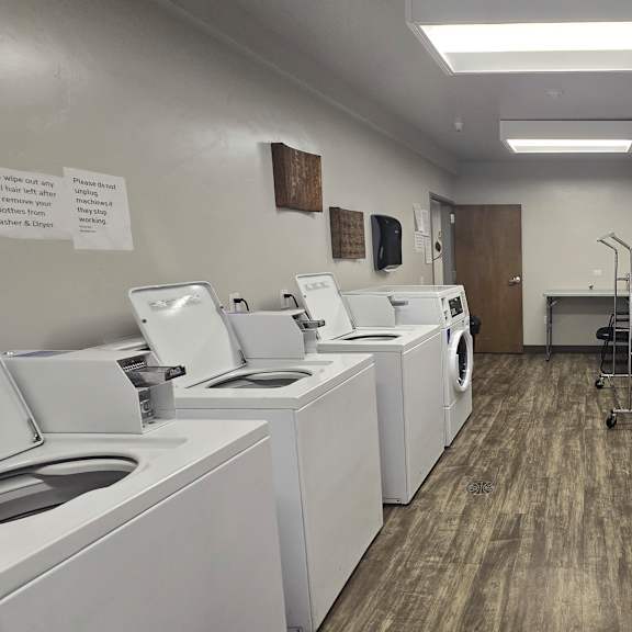 a laundromat with washers and dryers lined up.