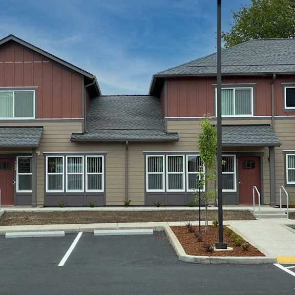 a two-story building with a parking lot in front.