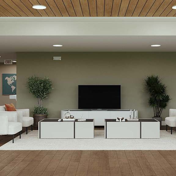 a living room with a white sofa set and a black television.