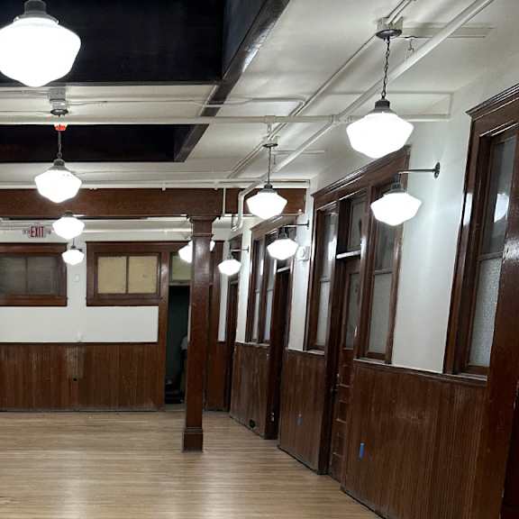 a view down the hallway of a courtroom with wood paneling and white lights hanging from the