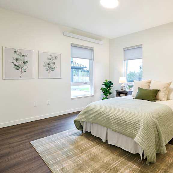 a bedroom with a bed and two windows