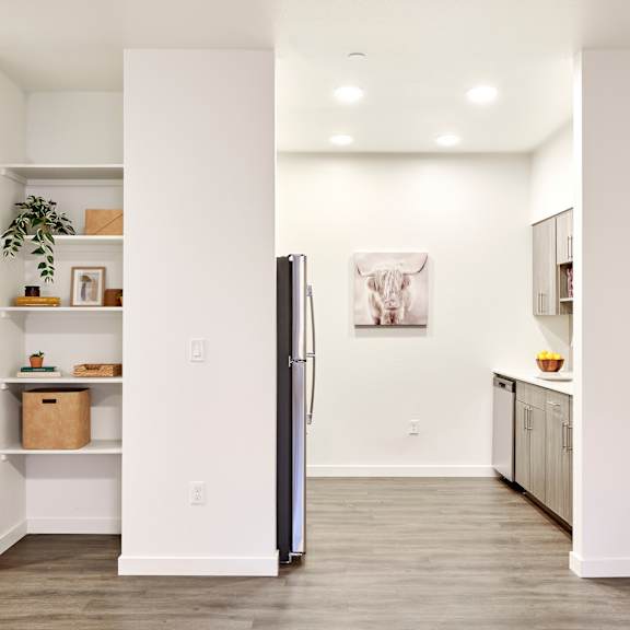 a kitchen with white walls and a stainless steel refrigerator
