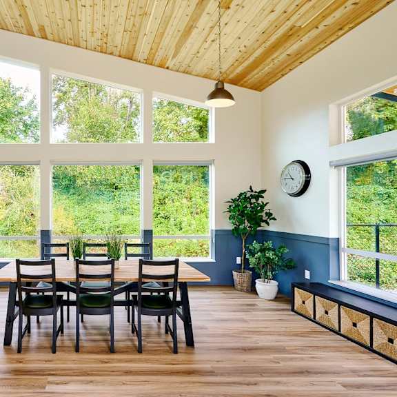 a dining room with a table and chairs and a large window