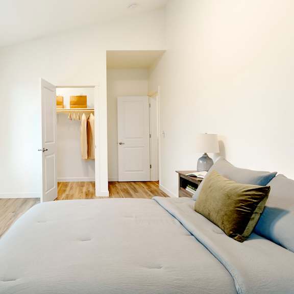 a bedroom with a large bed and a door to a closet