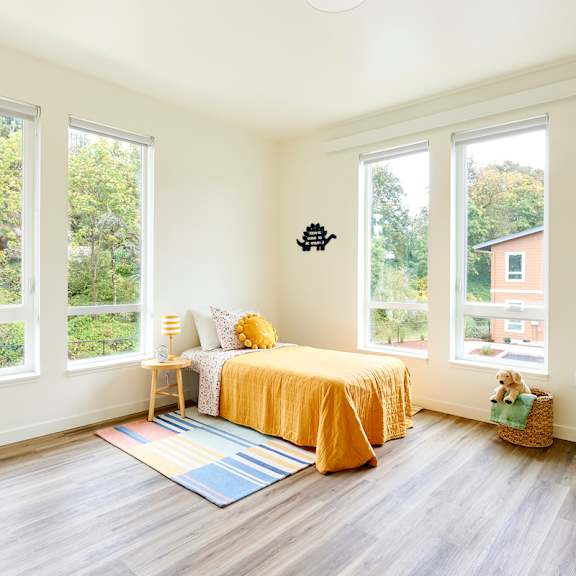 a bedroom with a bed and three windows