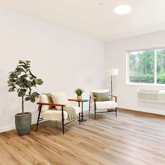 a living room with a large window and wooden floors