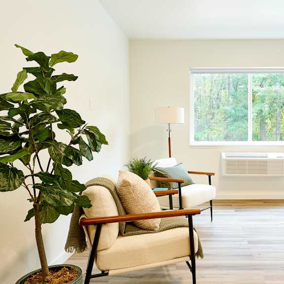 a living room with a chair and a window