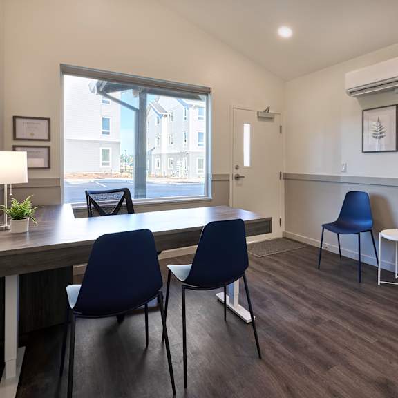 a dining room with a table and chairs and a window